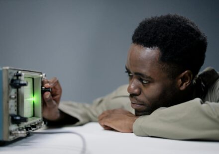 a man holding the knob of an electronic equipment